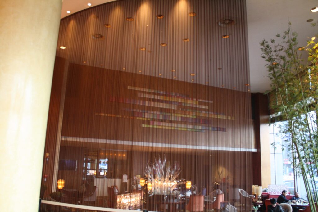 Vertical metal mesh curtains screening a bar and dining area