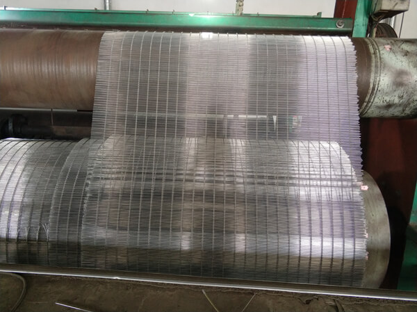 Stainless steel mesh running through a weaving machine
